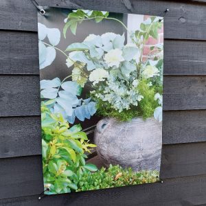 Tuinposter kruik met bloemen in de tuin