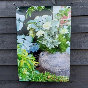 Tuinposter kruik met bloemen in de tuin