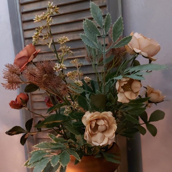 Een boeket zijden bloemen in prachtige klassieke kleuren, variërend van oud roze tot diep rood.