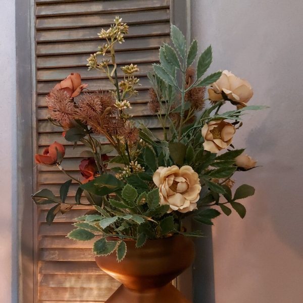 Een boeket zijden bloemen in prachtige klassieke kleuren, variërend van oud roze tot diep rood.