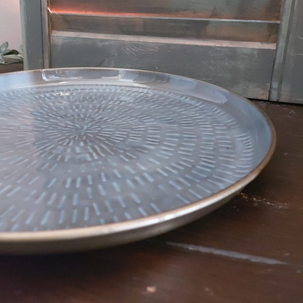 Metalen schaal met een afwerking in grijs en ijsblauw met een doorsnede van 30 cm, van het merk Mansion Atmosphere.