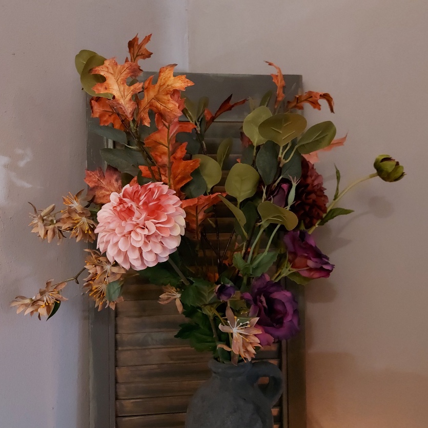 Compleet kunstbloemen boeket met bloemen in warme herfstkleuren.