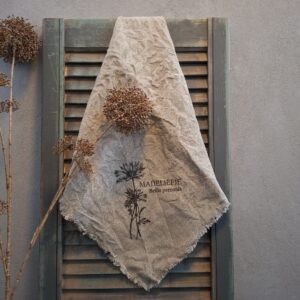 Shabby doek van linnen in een naturel kleur, met de afbeelding van een madeliefje.