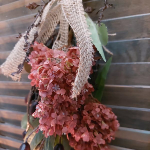 Toef van zijdenbloemen in warme winterkleuren, bij elkaar gebonden met jute koord en lint.