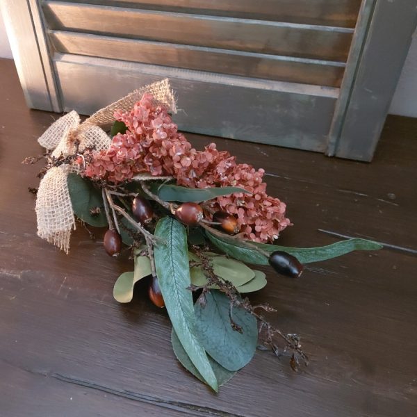 Toef van zijdenbloemen in warme winterkleuren, bij elkaar gebonden met jute koord en lint.