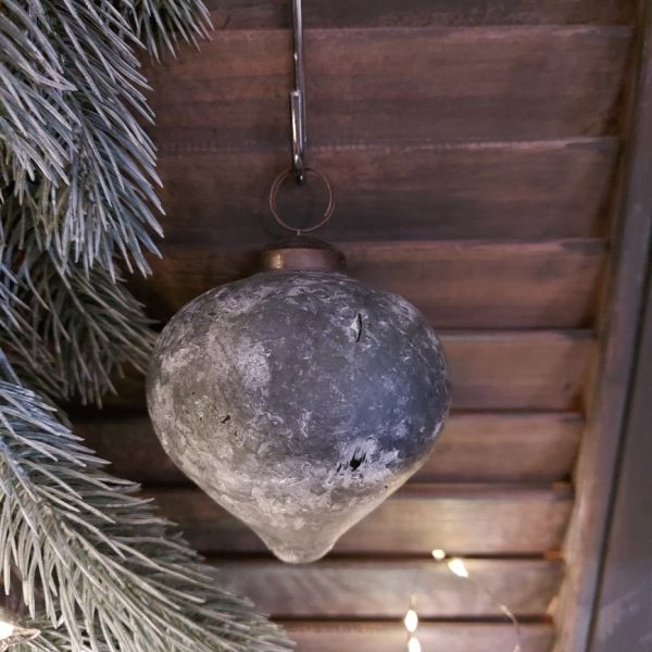 Glazen kerstbal in de vorm van een tol, uitgevoerd in een mat groene kleur.