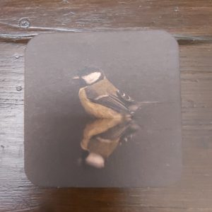 Onderzetter van viltkarton met de afbeelding van een koolmeesje. Dubbelzijdig bedrukt.