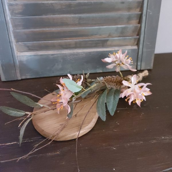 Toef van zijdenbloemen, opgebonden aan een plankje van Mangohout.