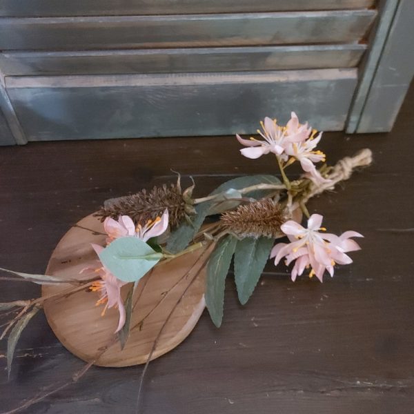 Toef van zijdenbloemen, opgebonden aan een plankje van Mangohout.