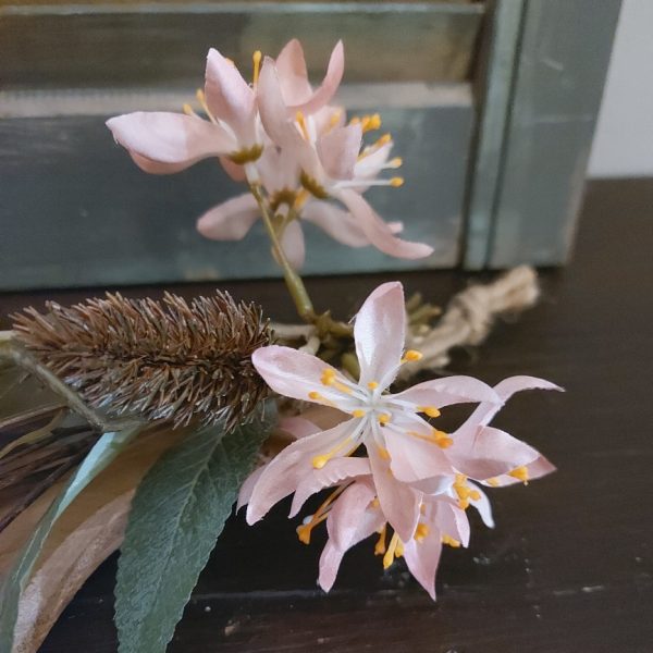 Toef van zijdenbloemen, opgebonden aan een plankje van Mangohout.