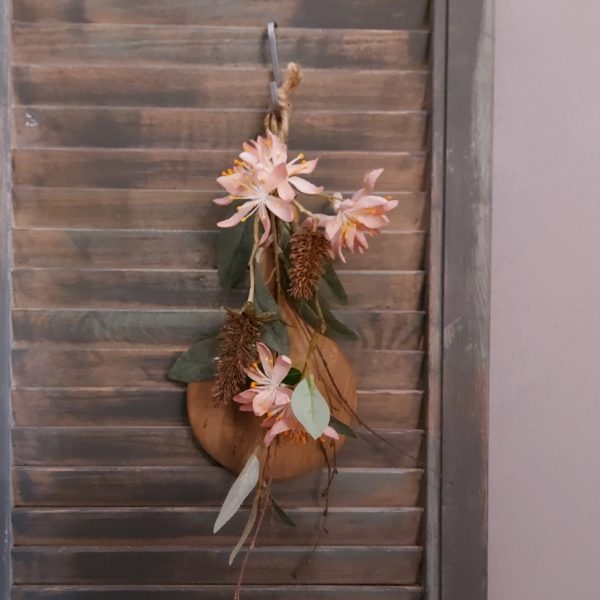 Toef van zijdenbloemen, opgebonden aan een plankje van Mangohout.