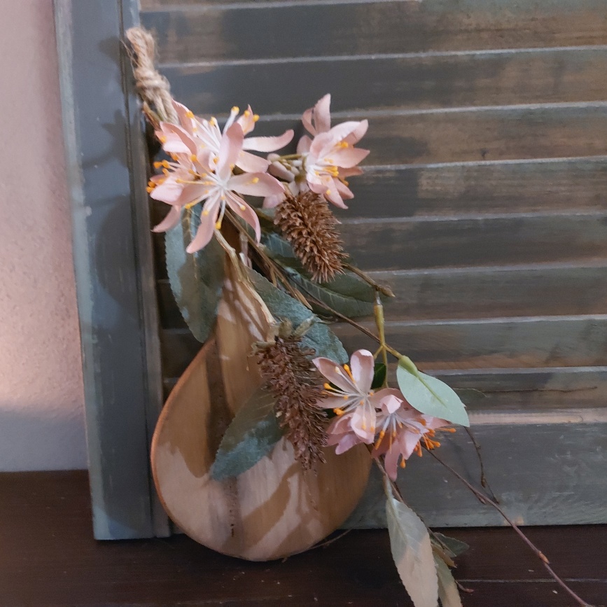 Toef van zijdenbloemen, opgebonden aan een plankje van Mangohout.