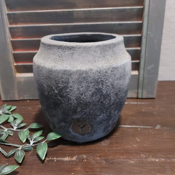 Bloempot van aardewerk in een donkergrijze kleur, met licht reliëf, van het merk Brynxz uit de serie Stone Black.