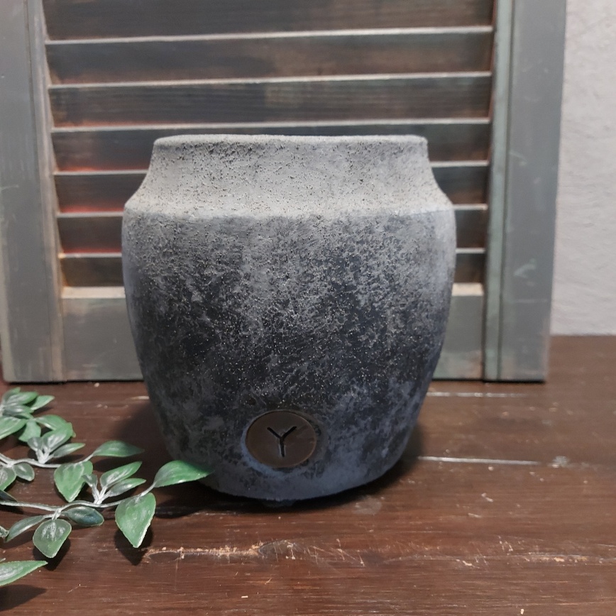Bloempot van aardewerk in een donkergrijze kleur, met licht reliëf, van het merk Brynxz uit de serie Stone Black.
