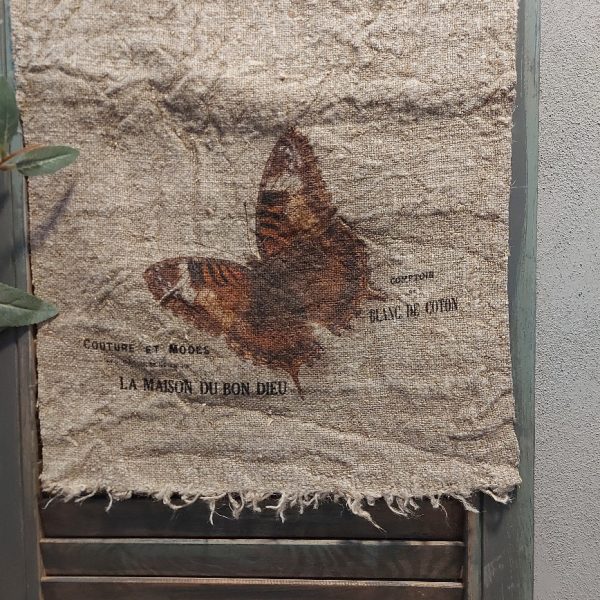 Shabby doek van linnen in een naturel kleur, met de afbeelding van een vlinder.