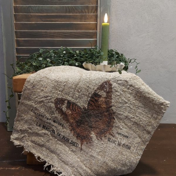 Shabby doek van linnen in een naturel kleur, met de afbeelding van een vlinder.