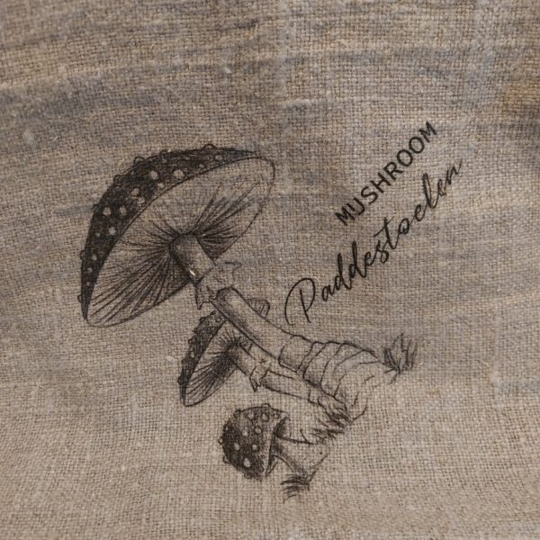 Shabby doek van naturel linnen met een afbeelding van paddenstoelen.