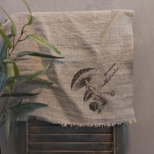 Shabby doek van naturel linnen met een afbeelding van paddenstoelen.