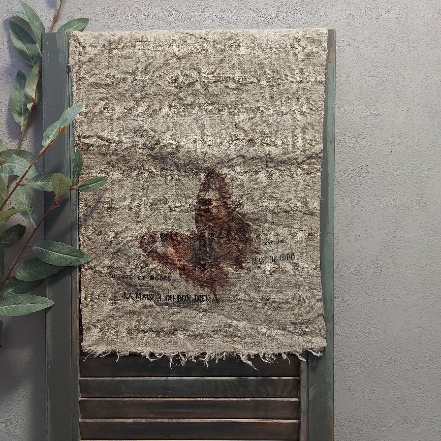 Shabby doek van linnen in een naturel kleur, met de afbeelding van een vlinder.