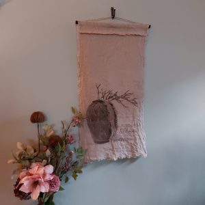 Wandkleed met de afbeelding van een stilleven van een pot met takken, gedrukt op naturel kleurig Shabby linnen.