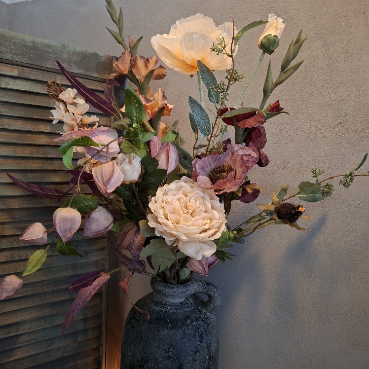 Boeket zijden bloemen met zomerse bloemen in warme kleuren.