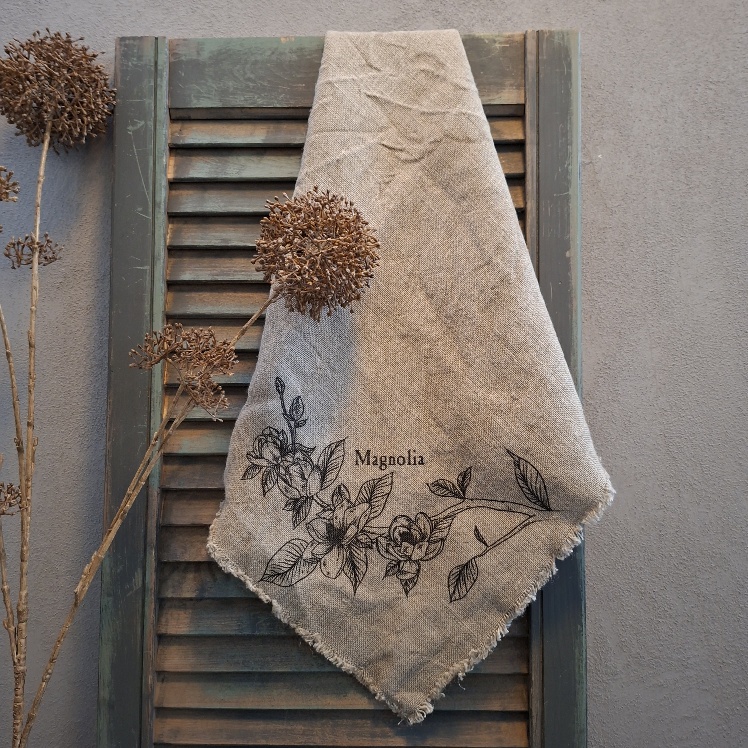 Shabby doek van linnen in een naturel kleur, met de afbeelding van een tak met Magnolia bloemen.