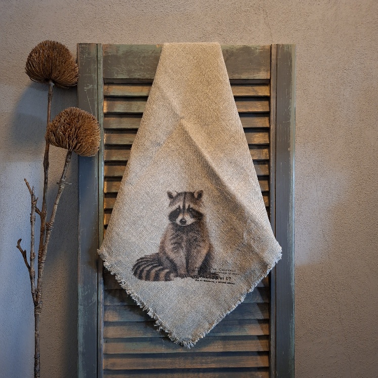 Shabby doek van linnen in een naturel kleur, met de afbeelding van een wasbeer.