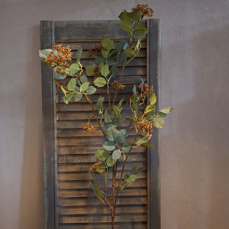 Twijg met groen blad en bruine vruchtjes in een kunstvariant, van het merk Sylxz.